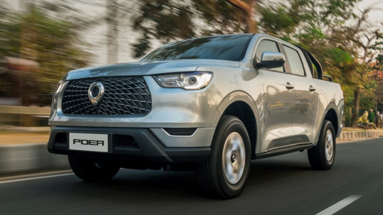 Camioneta PickUp 4x4 GWM Poer color gris siendo conducida en carretera con fondo natural.