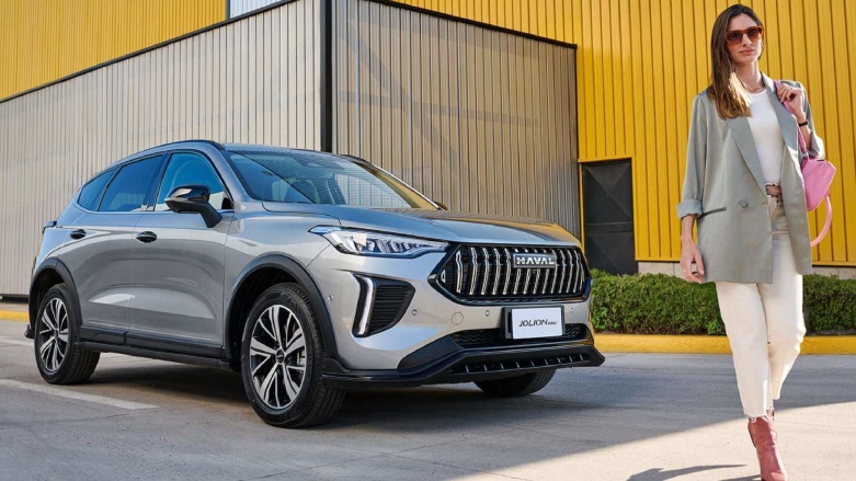 SUV New Jolion Pro GWM color gris con rines de lujo con una mujer caminando frente a ella.